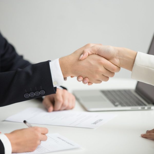 hr-handshaking-successful-candidate-getting-hired-new-job-closeup-min